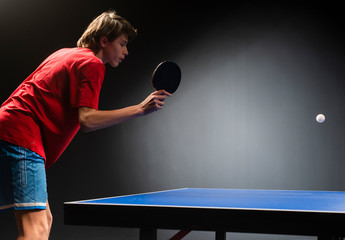 A boy playing ping-pong (table tennis)