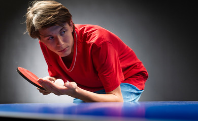 A boy playing ping-pong (table tennis)