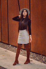 Beautiful girl model posing against the background of the modern building