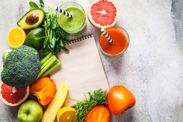 Green and orange detox smoothie in glass. Ingredients for detox smoothie background. Healthy food concept.