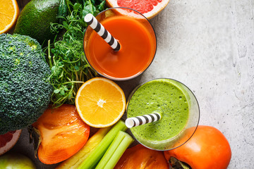 Green and orange detox smoothie in glass. Ingredients for detox smoothie background, copy space. Healthy food concept.
