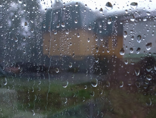 outside the window it is raining heavily, raindrops on the window, rainy weather