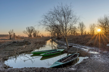 Beautiful sunset on the typical wooden boats of the wetland called Padule di Fucecchio, Porto delle Morette, Tuscany, Italy