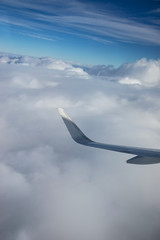 Naklejka na ściany i meble Wing of airplane above clouds