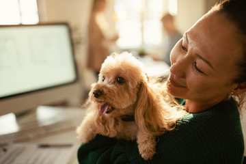 Asian businesswoman and her poodle at pet friendly office.