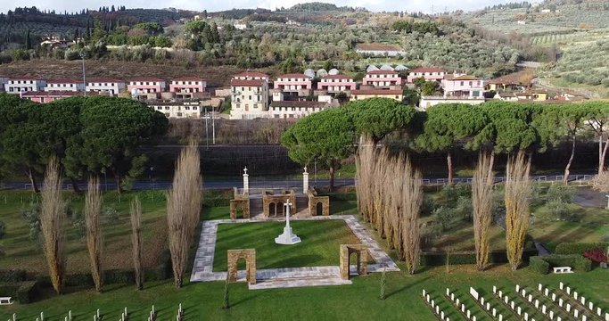 Cemetery full of white graves with small village in background. UK British and American cemetery close to the Arno river. San Jacopo al Girone, Fiesole Florence Italy