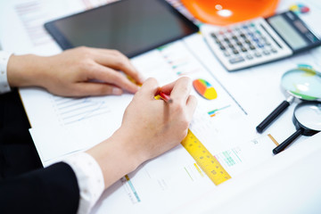 Architect or engineer working project accounting with graph with tools in office, Construction account concept.