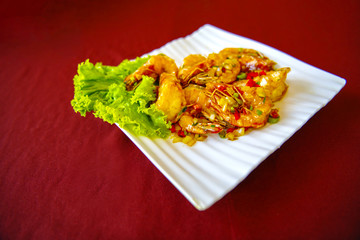 Shrimp Stir in sour sauce tasty white plates on a table covered with a red cloth