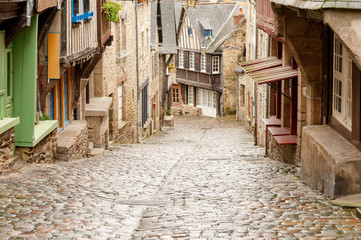 Fototapeta na wymiar Medieval cobblestone Rue du Jerzual street with timber-framed houses and shops in historic Dinan, Brittany, France