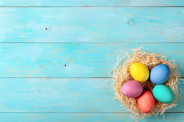 Easter concept. Colorful eggs on blue wooden background with copy space for text. Top down view or flat lay