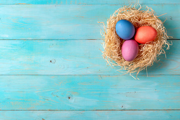 Easter concept. Colorful eggs on blue wooden background with copy space for text. Top down view or flat lay