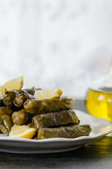 Traditional Turkish Dolma, Sarma or Dolmades,  Eating Traditional Mediterranean Dish Dolmadakia or Stuffed Grapes Leaves on Rustic Background