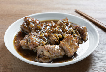 close up of stir fried pork rib with black pepper sauce in a ceramic dish on wooden table. homemade style food concept.