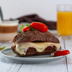 Rye bread sandwich with melted cheese and vegetables