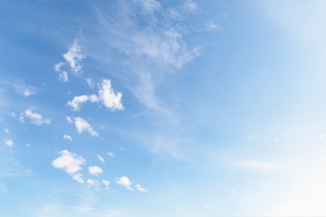 Beautiful white small soft fluffy clouds on a pale blue sky background