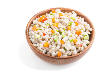 Fototapeta na wymiar Pearl barley porridge with vegetables in wooden bowl isolated on white background. Side view, close up.