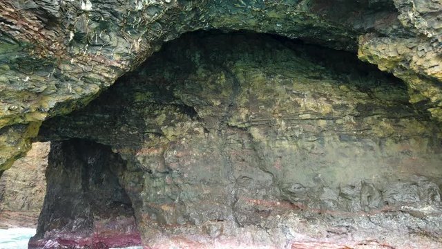 4K Hawaii Kauai Boating on ocean floating toward rock arch tunnel