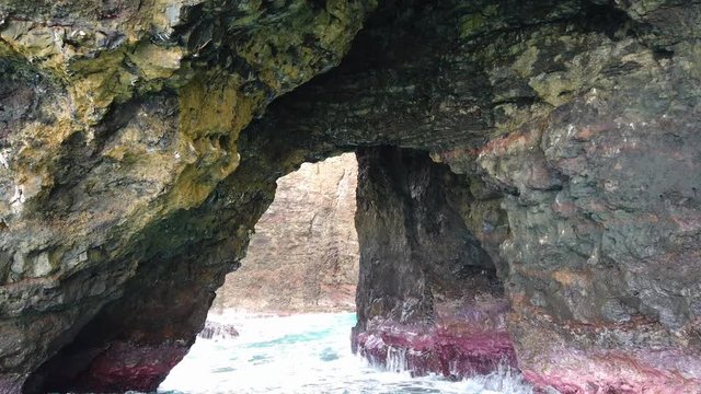 4K Hawaii Kauai Boating on ocean floating near rocky arch