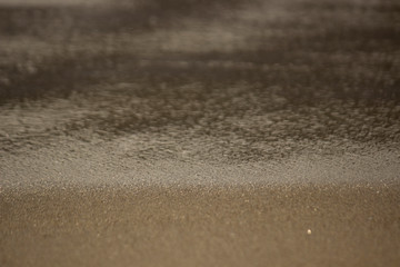 Fototapeta na wymiar Wet seashore sand texture at morning