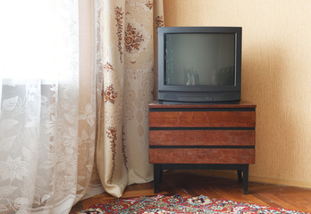 Vintage Television on wooden antique closet, old design in a home