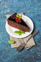 A piece of delicious chocolate cake with fresh berries and mint