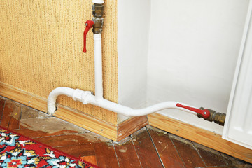White radiator in an apartment. Radiator.White radiator with tap to shut off the water supply to...