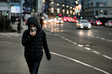 Fototapeta premium Air Pollution Concept - Young Person with Breathing Mask in the City