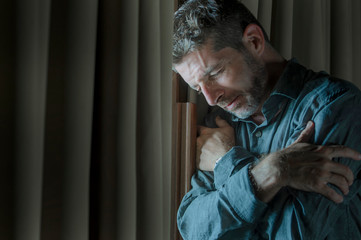 dramatic portrait of depressed and sick man suffering from psychosis illness or mental disorder looking weird and helpless in psychiatric and psychological problem concept