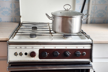 old retro gas stove with pans and kettle. photo of obsolete kitchen utensils. 