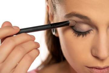 Portrait of young beautiful woman applying eyeshadow