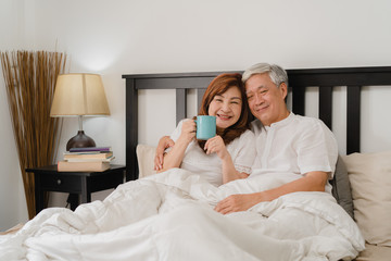 Asian senior couple talking on bed at home. Asian Senior Chinese grandparents, husband and wife...