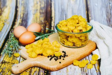 Pâtes crues dans un bol en verre et oeufs sur la table de cuisine
