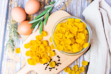 Pâtes crues dans un bol en verre et oeufs sur la table de cuisine