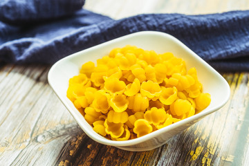 Pates coquilles dans un bol blanc sur la table de cuisine