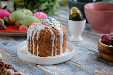 Easter cake and colorful eggs on a wooden blue table