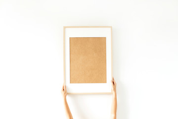 Female hands hold blank photo frame with empty mockup copy space. Minimal art concept.