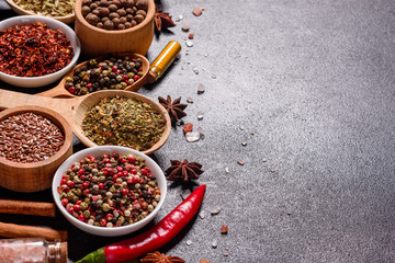 A set of spices and herbs. Indian cuisine. Pepper, salt, paprika, basil and other on a dark background