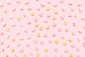 Many multi-colored marshmallows in the shape of hearts are scattered randomly.  Festive background.