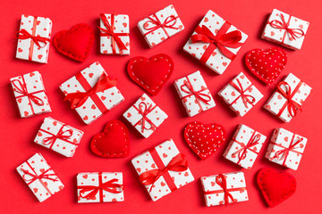 Fototapeta na wymiar Top view of white gift boxes and red textile hearts on colorful background. Valentine's Day concept