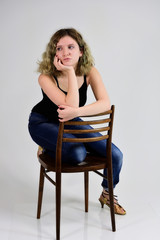 A young woman sits on a chair