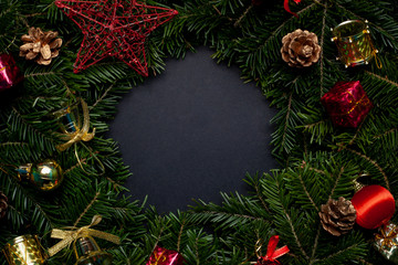 Fototapeta na wymiar Christmas wreath decorated with toys and a red star with a black background in the center