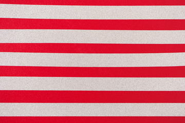 Silver glitter horizontal stripes on red background. Holiday pattern