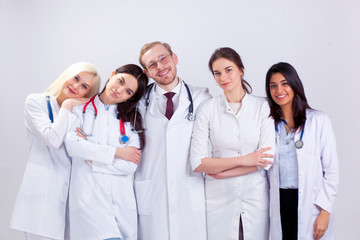 A team of young doctors in white robes. A group of medical students of different nationalities are looking in the cell.