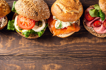 Assorted sandwiches on wooden background. Healthy food concept with copy space. Top view.