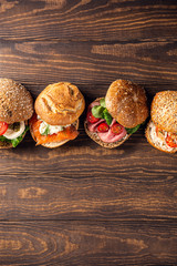 Assorted sandwiches on wooden background. Healthy food concept with copy space. Top view.