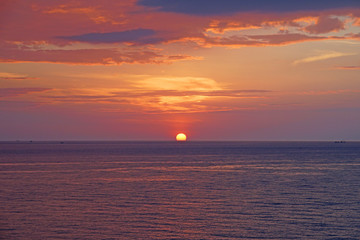 Nature seascape of Tranquil sunset scene. Sun and dark clouds with twilight sky over the sea at phuket Thailand - image Travel nature backdrop background and copy space                           