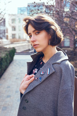 Summer sunny lifestyle fashion portrait of young stylish hipster woman walking on the street