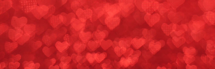 The bokeh texture in the form of many small hearts on a red background.