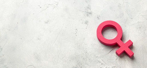 Gender symbols of a woman of pink color on a gray background
