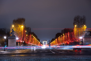 long exposure night view of Paris, France, champs élysées famous landmark place with arc de...